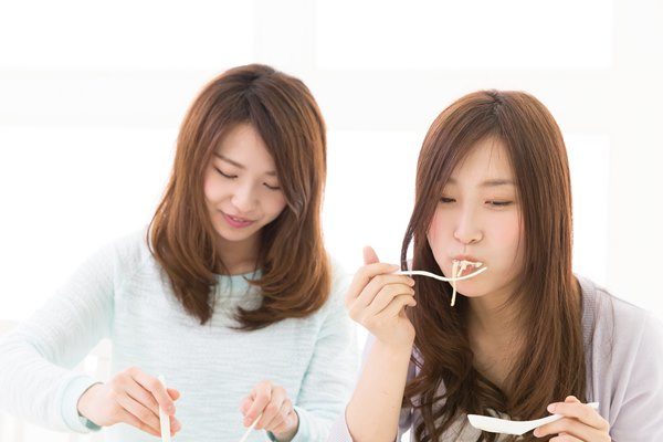 パスタを食べる二人の女性